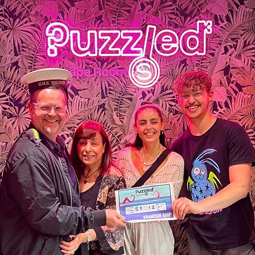 A family having their photo taken after playing at Puzzled Escape Rooms